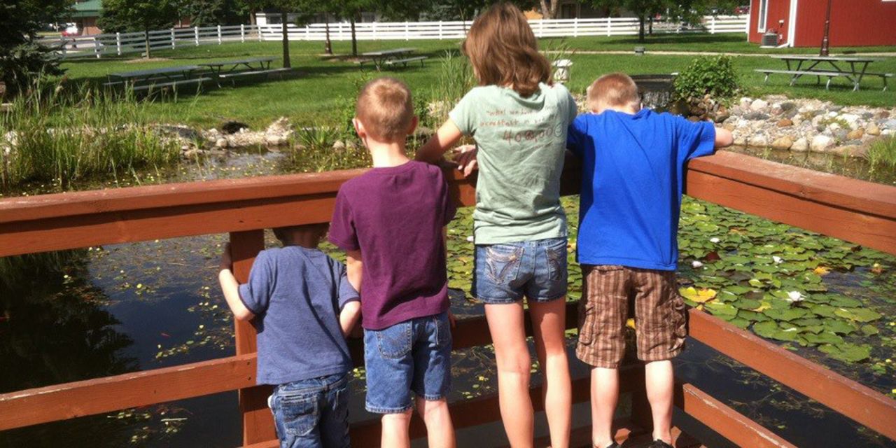 four children looking over a railing