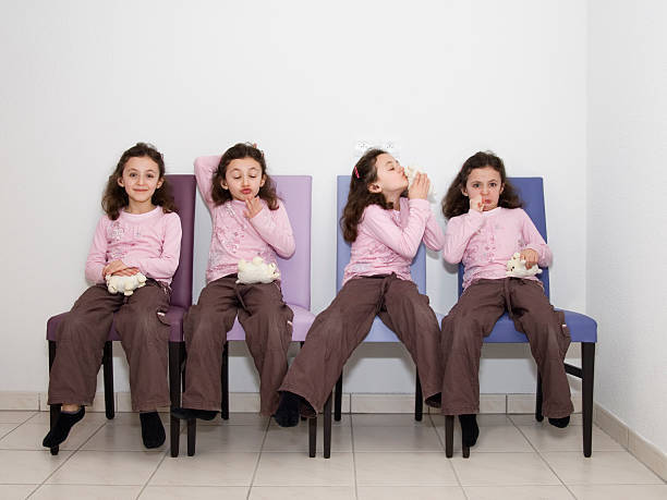 four identical 8-year-old girls wearing purple shirts and brown pants