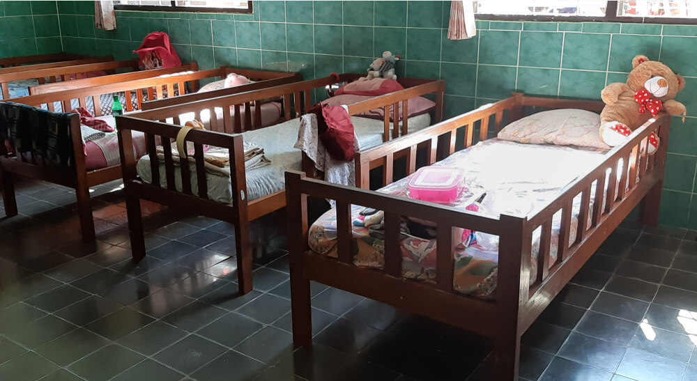 row of children's beds in an orphanage