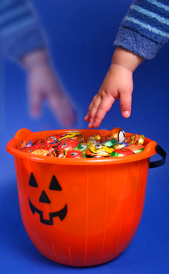 two toddler hands reaching for candy, one is ghostly