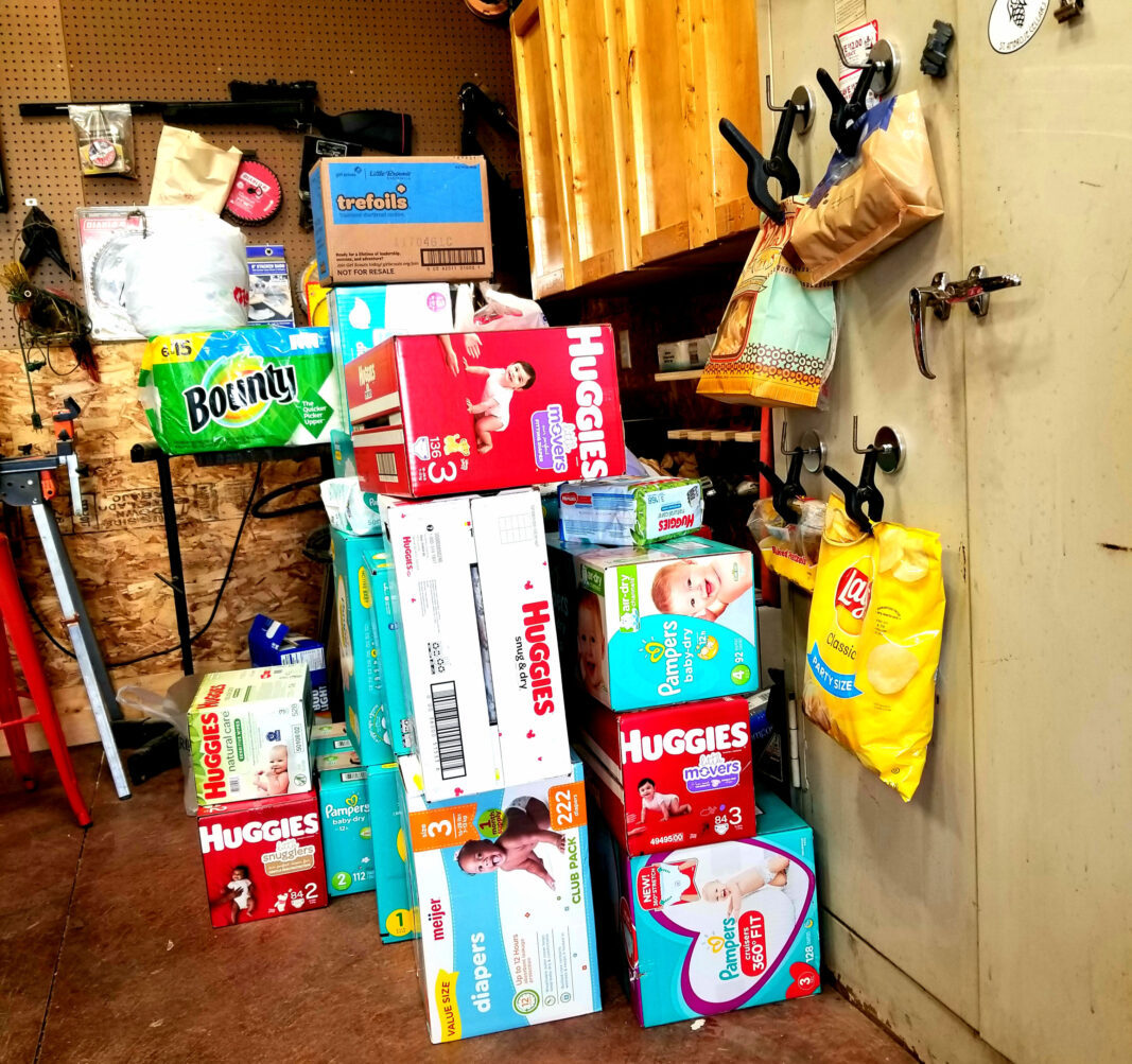 stack of boxes of diapers and chips in a garage