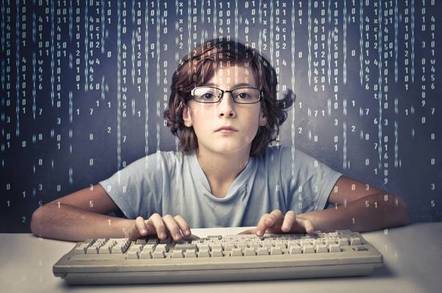 brown haired little boy wearing glasses pouring over a computer screen